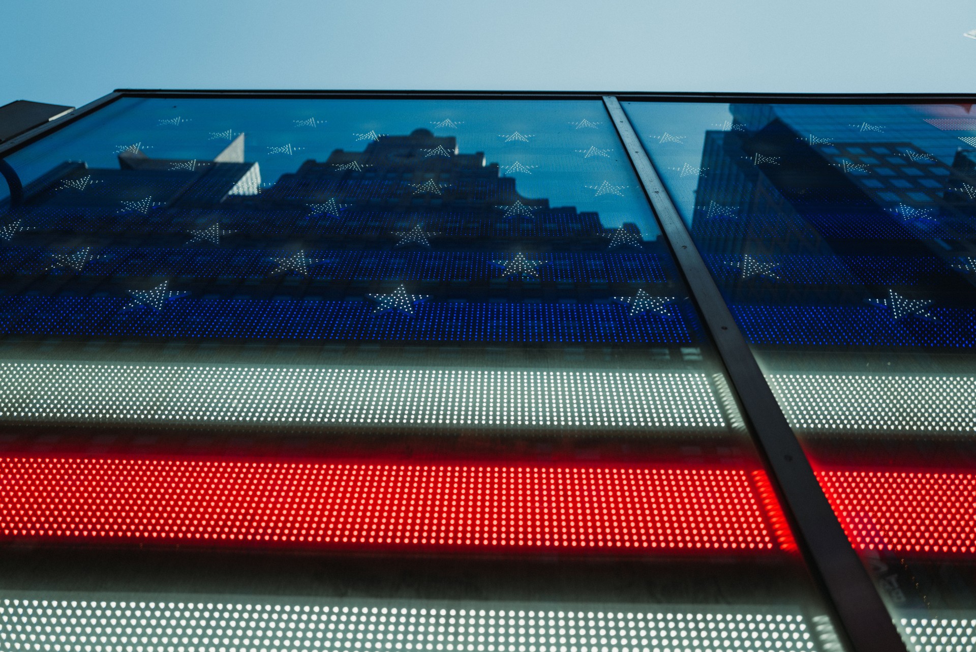 Skyscrapers reflected on American flag panel in Times square